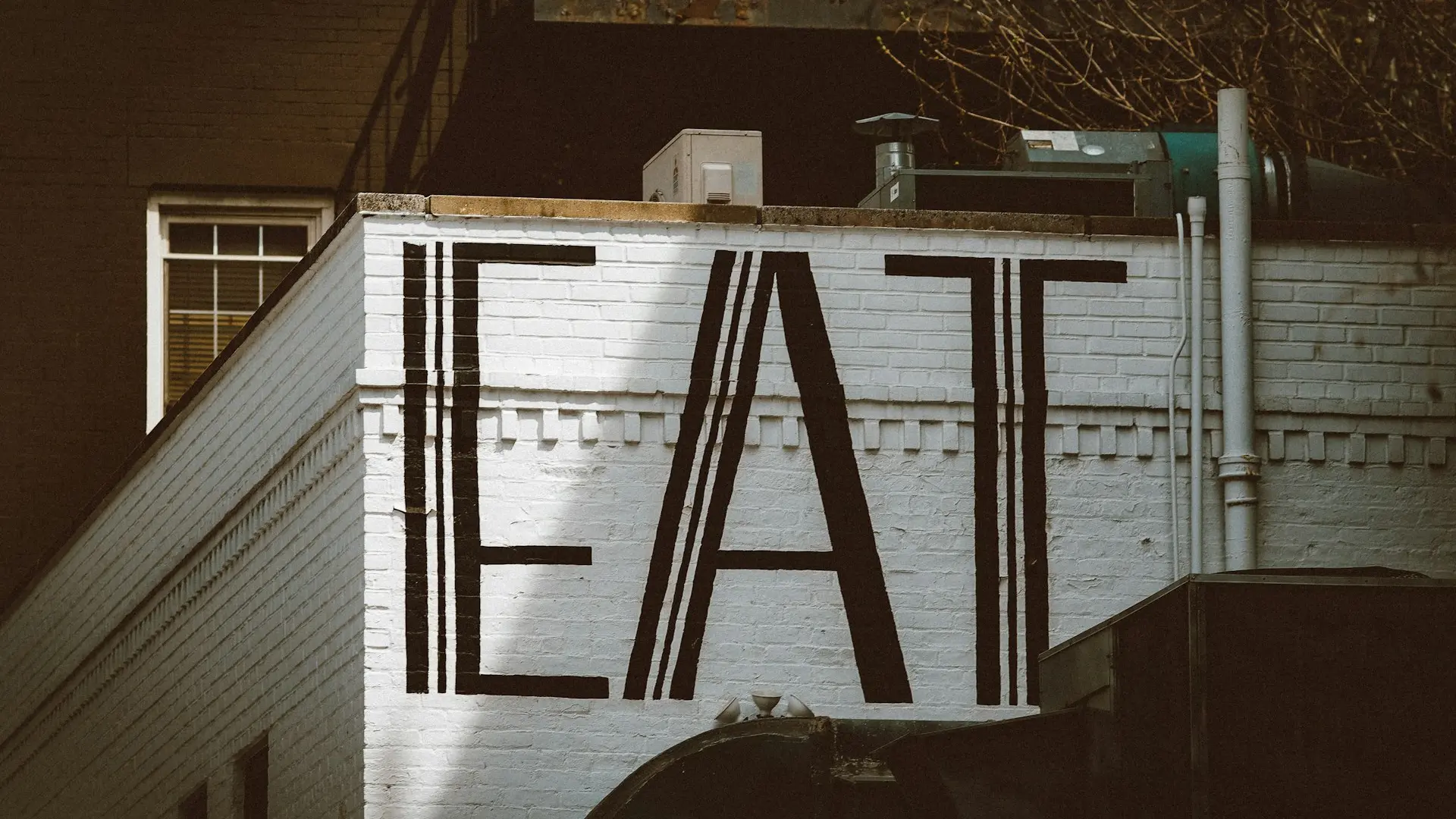 a sign that says eat on the side of a building