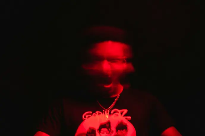 a man in a dark room with a red light